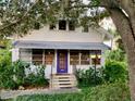 Inviting front exterior showcasing a charming home with a distinctive purple door and mature trees at 1107 S Prospect Ave, Clearwater, FL 33756