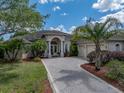 Beautiful front exterior with circular driveway, lush landscaping, and a charming, inviting facade at 13538 Thoroughbred Dr, Dade City, FL 33525