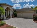 Spacious two-car garage adjacent to the main house with a brick paved drive at 13538 Thoroughbred Dr, Dade City, FL 33525
