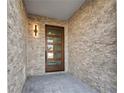 Stylish front entryway with a modern door, stone walls, and block paved floor at 187 145Th E Ave # 4, St Petersburg, FL 33708