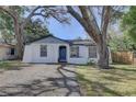 Inviting home with a beautiful blue door, well-kept lawn, and mature trees at 2009 E Eskimo Ave, Tampa, FL 33604