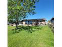 Spacious backyard with lush lawn, partial shade, and solar panels on the home's roof at 2110 Society Dr, Holiday, FL 34691