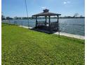 Waterfront property featuring a gazebo and boat dock, perfect for enjoying lakeside living at 2110 Society Dr, Holiday, FL 34691