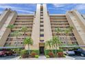 A low angle of a condo building with balconies, palm trees, and covered parking at 2618 Cove Cay Dr # 801, Clearwater, FL 33760