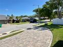 Neighborhood street view with mature trees, well-maintained lawns and brick paver driveways at 3000 Tangerine Ter, Palm Harbor, FL 34684