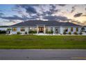Beautiful exterior view of a modern home featuring a well-manicured lawn and elegant landscaping at dusk at 3409 Gulf City Rd, Ruskin, FL 33570