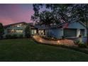 A scenic home at twilight with front walkway lights, a manicured lawn, and a classic two-car garage at 3603 Schefflera Rd, Tampa, FL 33618