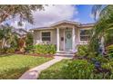 Well-maintained front yard with a charming entrance, featuring a cozy porch and manicured landscaping at 477 44Th N Ave, St Petersburg, FL 33703