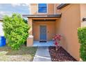 Cozy front porch with a gray front door, complemented by fresh landscaping and a welcoming ambiance at 5147 Brickwood Rise Dr, Wimauma, FL 33598