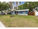 Landscaped single-story home with blue paint, white trim, and a well-manicured front lawn at 5806 12Th S Ave, Tampa, FL 33619