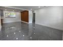 Bright living room featuring stylish gray tile flooring and contemporary wood accent wall at 5806 12Th S Ave, Tampa, FL 33619
