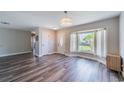 Inviting living room with laminate flooring, a large window with lots of natural light, and modern light fixtures at 8421 Millwood Dr, Tampa, FL 33615