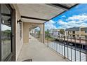 A balcony with metal railing overlooks neighborhood and sky with clouds at 8703 Bardmoor Blvd # 304, Seminole, FL 33777