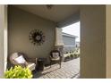 Comfortable front porch featuring wicker seating, a small table, and decorative elements for a cozy ambiance at 8732 Rain Song Rd, Sarasota, FL 34238