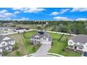 Expansive aerial view of a modern home with a three-car garage, complemented by a lush, fenced backyard and neighborhood at 9843 Cabernet Ave, Seffner, FL 33584