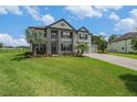 Beautiful two-story home with well-manicured lawn, palm trees, and a brick-paved driveway leading to the garage at 9843 Cabernet Ave, Seffner, FL 33584
