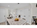 Open kitchen featuring a center island with seating, white cabinets, and modern fixtures at 100 4Th S Ave # 132, St Petersburg, FL 33701