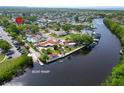 Waterfront property featuring a private boat ramp, mature trees, and lush landscaping, with beautiful views of the water at 10717 Drummond Rd, Tampa, FL 33615