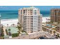 Luxury beachfront condo building with balconies and palm trees overlooking a sandy beach and ocean at 11 San Marco St # 407, Clearwater Beach, FL 33767