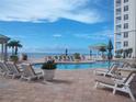 Relaxing poolside featuring lounge chairs, palm trees, and clear blue skies at 11 San Marco St # 407, Clearwater Beach, FL 33767