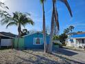 Charming blue home exterior featuring palm trees, rock landscaping, and a cozy, inviting atmosphere at 126 119Th Ave, Treasure Island, FL 33706