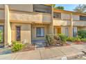Beige two-story townhouse featuring a welcoming entrance, small garden, and convenient walkway at 1424 Highland Ridge Cir, Brandon, FL 33510