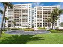 Luxury high-rise beachfront condo building with lush landscaping, circular driveway, and direct beach access at 1460 Gulf Blvd # 108, Clearwater, FL 33767