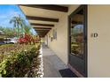 Exterior walkway leading to unit with well-maintained landscaping featuring tropical plants at 1701 Pinehurst Rd # 31D, Dunedin, FL 34698