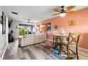 Bright living room with beachy decor, wood floors, and a comfortable leather sectional sofa at 1701 Pinehurst Rd # 31D, Dunedin, FL 34698