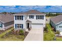 Two-story home with blue shutters, white exterior, and landscaping at 18023 Canopy Pl, Bradenton, FL 34211