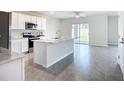Bright kitchen with stainless appliances, island and sliding door to backyard at 18023 Canopy Pl, Bradenton, FL 34211