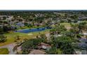 Expansive aerial view of the neighborhood showcasing lush greenery, a pond, and a nearby golf course at 1868 Juarez S Way, St Petersburg, FL 33712
