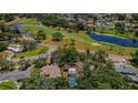 Overhead view of property and surrounding community near a golf course with lush trees and fairways at 1868 Juarez S Way, St Petersburg, FL 33712