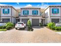 Close up of the townhome featuring a brick driveway, two car garage and blue shutters at 18737 Noble Caspian Dr, Lutz, FL 33558