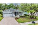Inviting single-Gathering home featuring a brick driveway, manicured lawn, and charming front porch at 19529 Lily Pond Ct, Brooksville, FL 34601