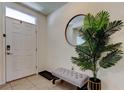 Welcoming entryway with tile flooring, a stylish bench, and a decorative mirror at 2933 Maiden Grass Isle, Wesley Chapel, FL 33543