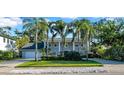 Elegant two-story home featuring mature palm trees, lush landscaping, and a spacious front yard at 4106 W Cleveland St, Tampa, FL 33609