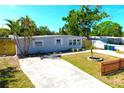 Well-maintained single-story home featuring a green lawn, landscaping, and a concrete driveway at 4106 W Montgomery Ter, Tampa, FL 33616