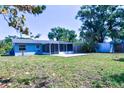 Spacious backyard featuring a covered, screened patio and ample green space surrounded by mature trees at 510 55Th Ne Ave, St Petersburg, FL 33703