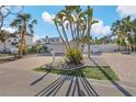 Inviting home exterior with brick driveway, tropical landscaping, and a well-maintained white picket fence at 5430 Avenida Del Mare, Sarasota, FL 34242
