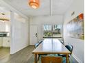 Light-filled dining room with a large window, modern decor, and stylish blue chairs at 5619 New York Ave, Sarasota, FL 34231