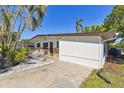 Bright single-story home featuring a concrete porch and meticulously maintained landscaping at 5619 New York Ave, Sarasota, FL 34231
