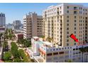 An aerial view captures the building's facade, balconies and rooftop pool with lounge area at 628 Cleveland St # 612, Clearwater, FL 33755