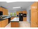 Kitchen with tile flooring, wood cabinets, white countertops, and modern black appliances at 7537 Old Pasco Rd, Wesley Chapel, FL 33544