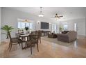 Open concept living room with a dining table, sofa, and large windows at 8932 Rocky Creek Dr, Tampa, FL 33615