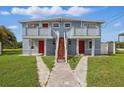 Two story duplex with walkway to the entrances, and matching red doors at 8940 Rocky Creek Dr, Tampa, FL 33615