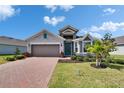 Beautiful home with a brick driveway, lush green lawn, and well-maintained landscaping at 11773 Little River Way, Parrish, FL 34219