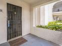 Secure front entryway with an iron gate, a 'welcome' mat, and decorative planter bed at 122 N Kings Ave # 101, Brandon, FL 33510