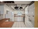 Efficient kitchen featuring white cabinetry, neutral countertops, and a combination washer-dryer unit at 122 N Kings Ave # 101, Brandon, FL 33510