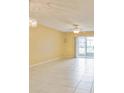 Bright living room with tiled floors, ceiling fan, and sliding glass doors leading to outdoor space at 122 N Kings Ave # 101, Brandon, FL 33510
